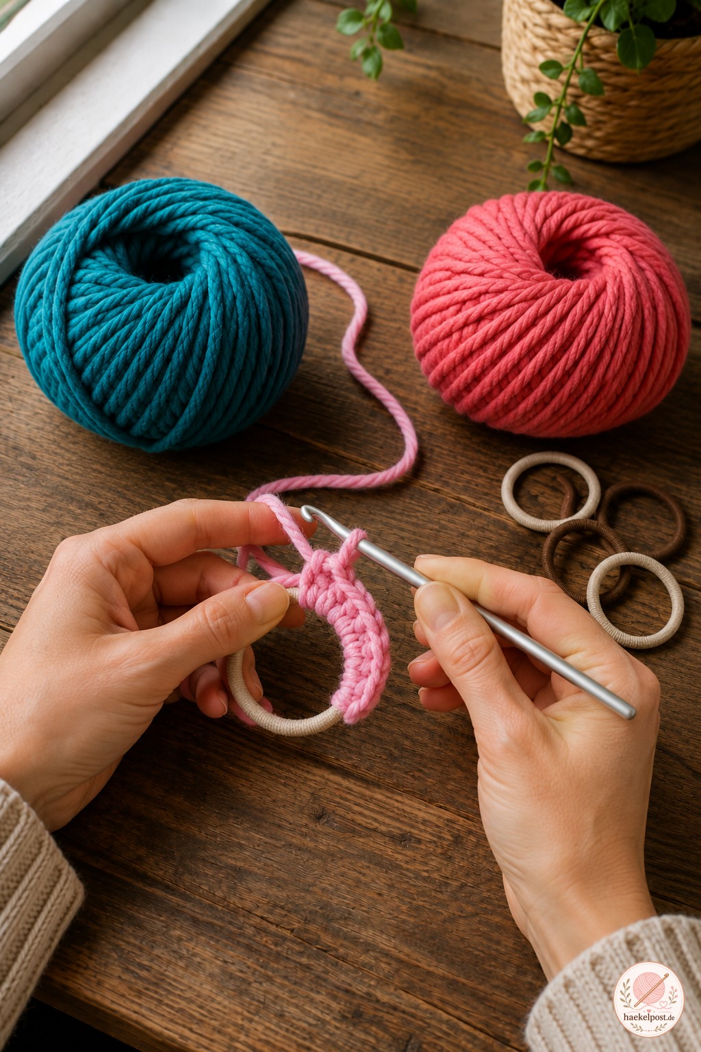 Rosa Garn wird um ein Gummiband gewickelt, um die zweite gekräuselte Scrunchie zu häkeln