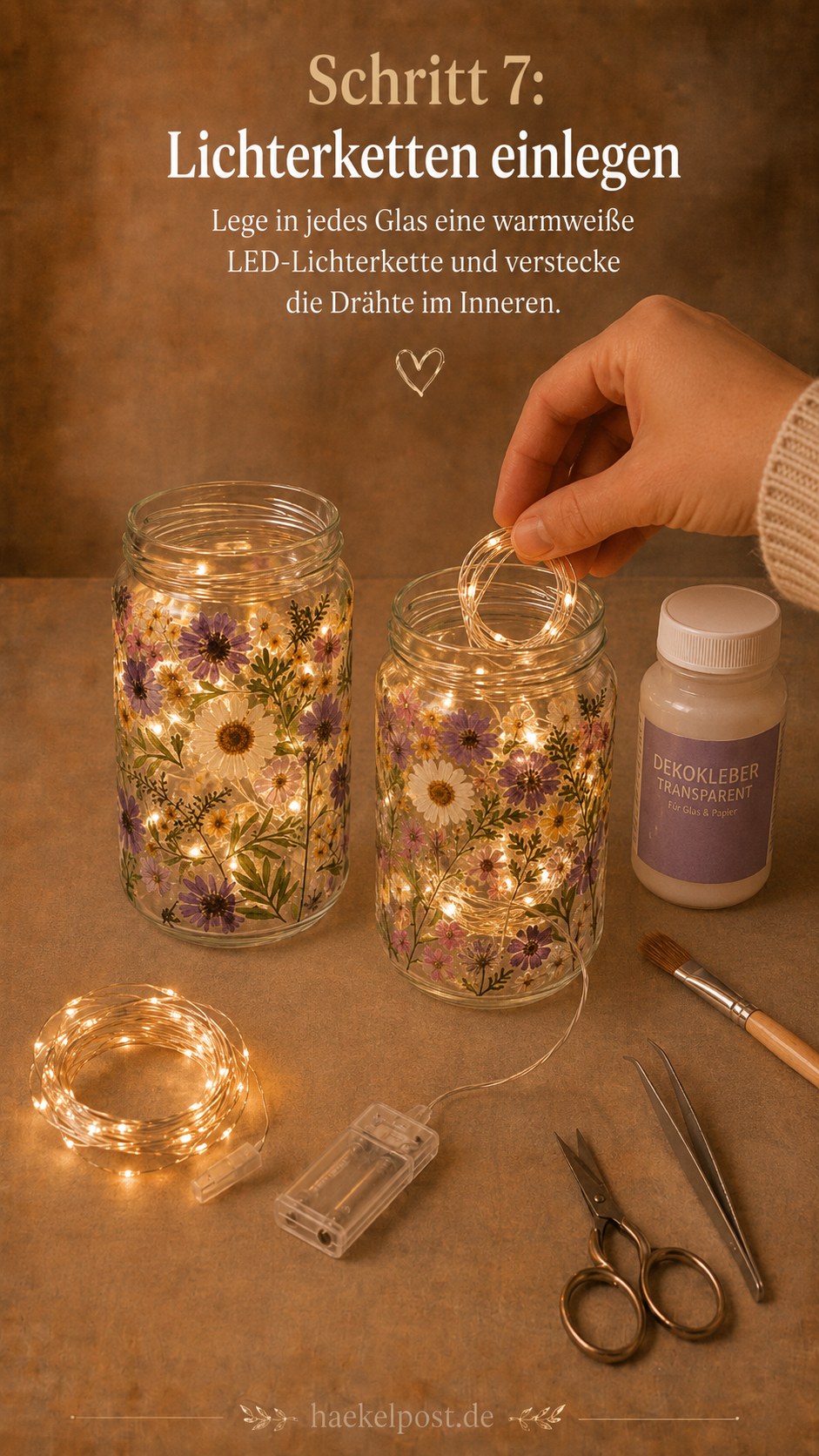 Eine warmweiße Lichterkette wird ins Einmachglas mit gepressten Blumen gelegt