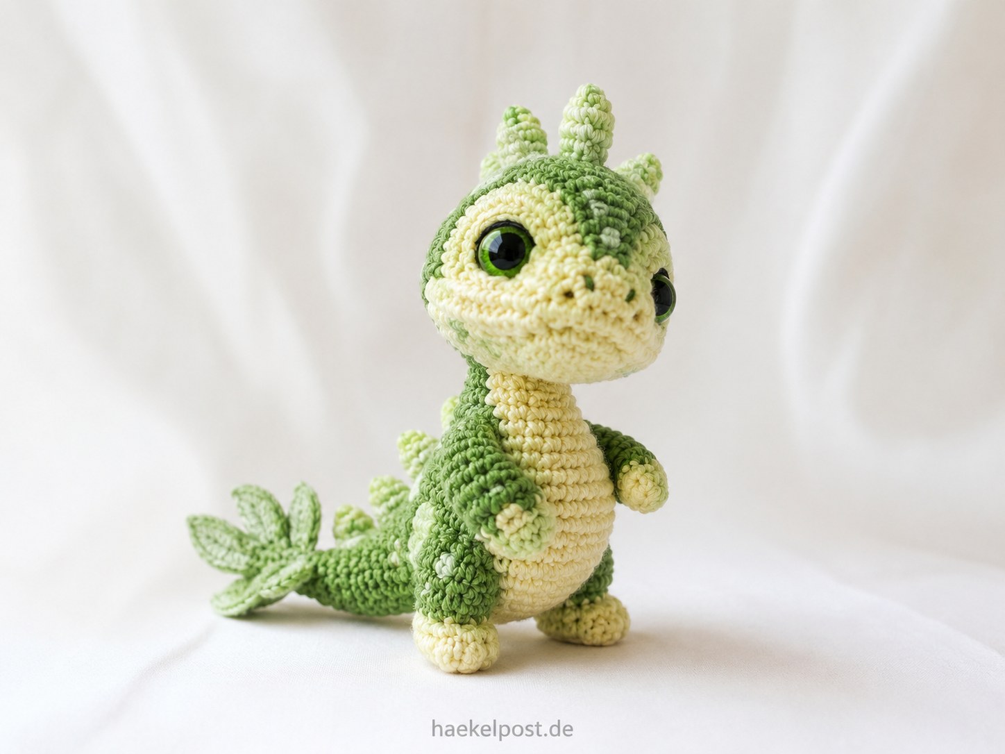 Grüner Baby-Drache als exotisches Amigurumi-Zootier mit Rückenstacheln und Kulleraugen